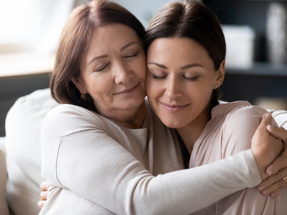 Two women hugging each other in a room.