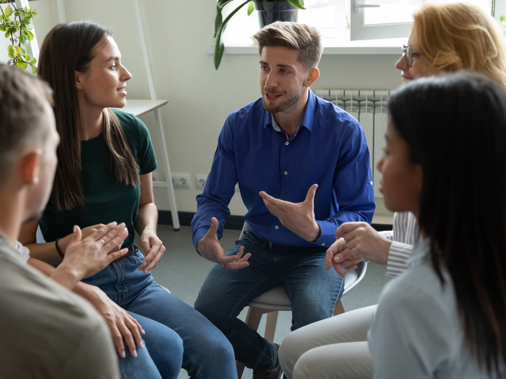 A group of people sitting in a circle talking.