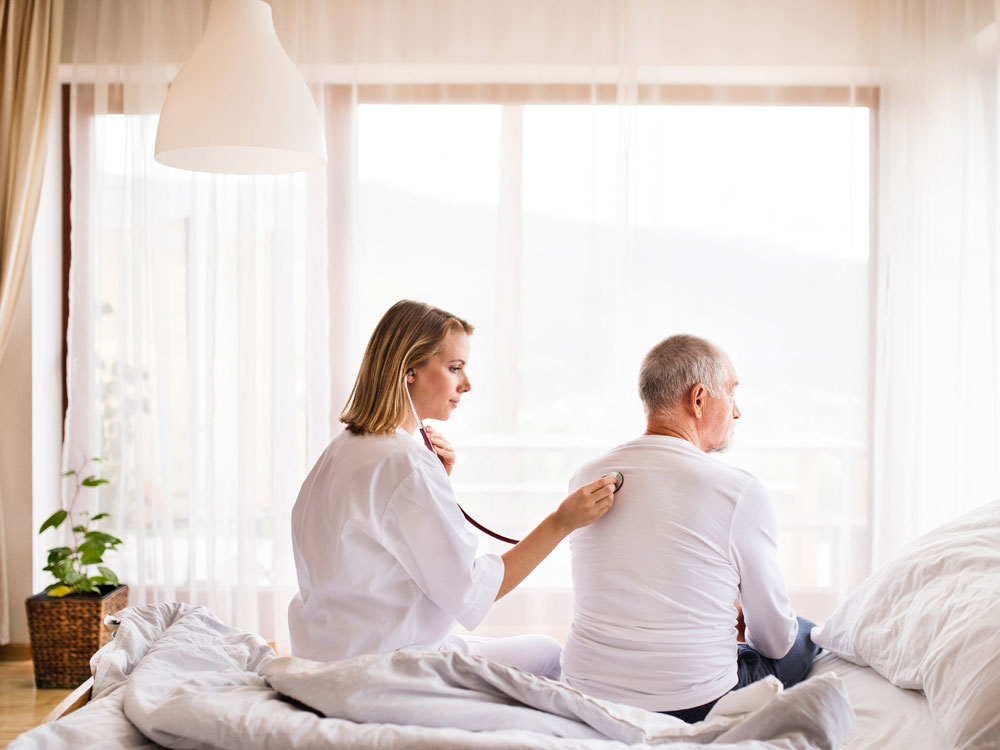 A woman sitting on the bed with a man.