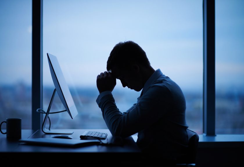 A man sitting at his desk in front of a computer.