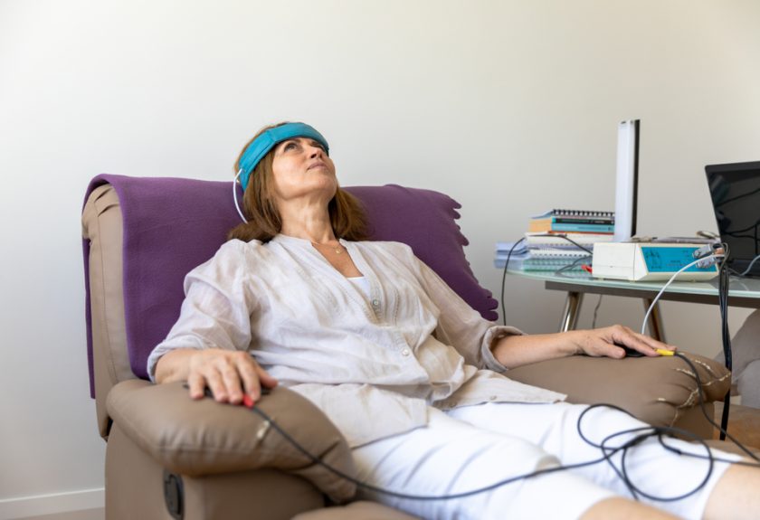 A woman sitting on top of a couch with her eyes closed.