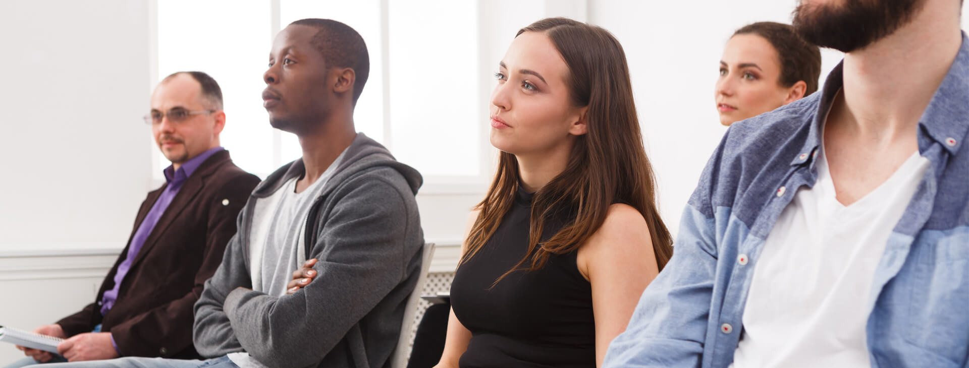 A woman in black dress sitting next to two men.