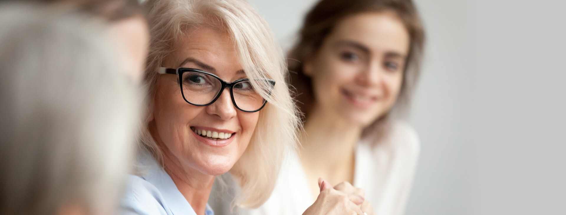 Two women smiling for a picture while wearing glasses.