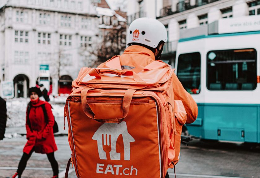 A person with an orange bag on the street.