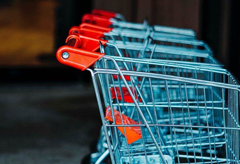 A row of shopping carts sitting in a parking lot.