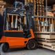 A forklift is parked in front of wooden pallets.