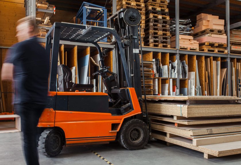 A forklift is parked in front of wooden pallets.